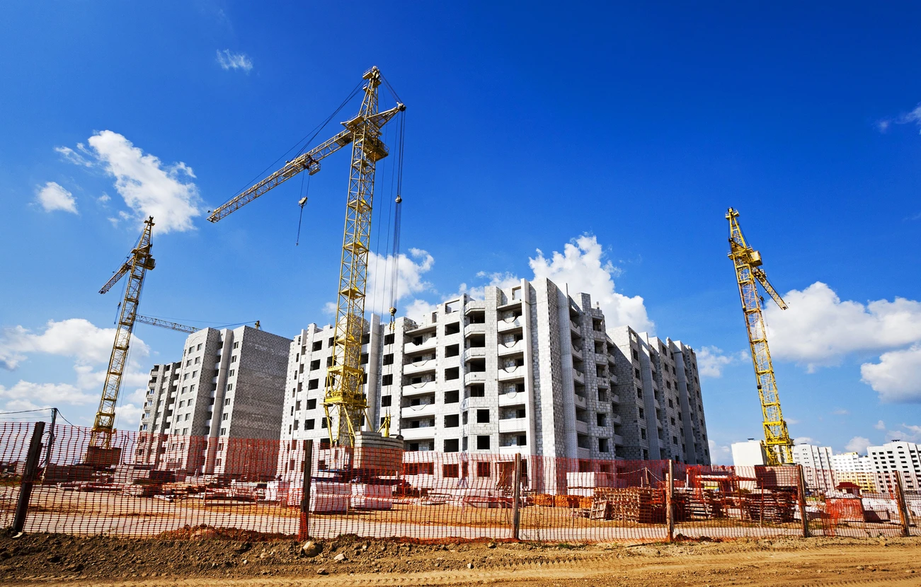 Chantier de construction extérieur avec plusieurs immeubles résidentiels en béton en cours d'édification