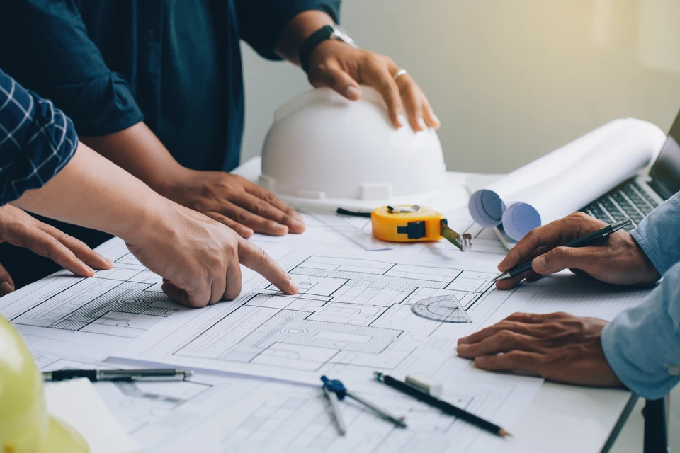 Réunion d'ingénieur ou d'architecte pour le projet de travail avec les partenaires et vérifier les plans de construction sur le nouveau projet avec des outils d'ingénierie sur le site de travail