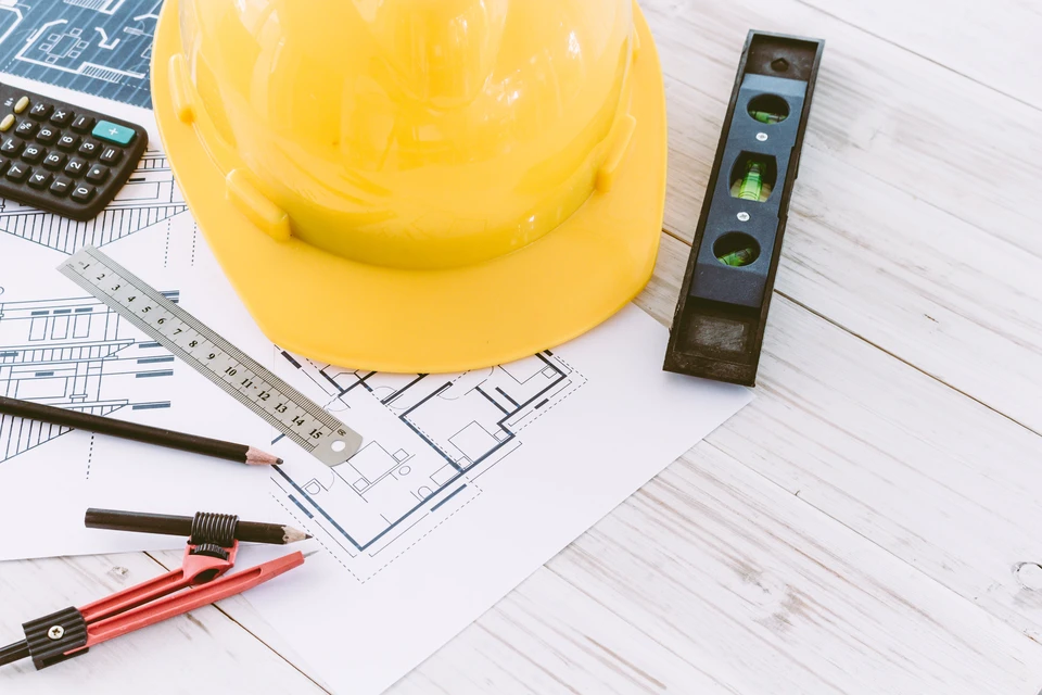 Chantier de construction extérieur avec deux professionnels du bâtiment consultant des plans architecturaux