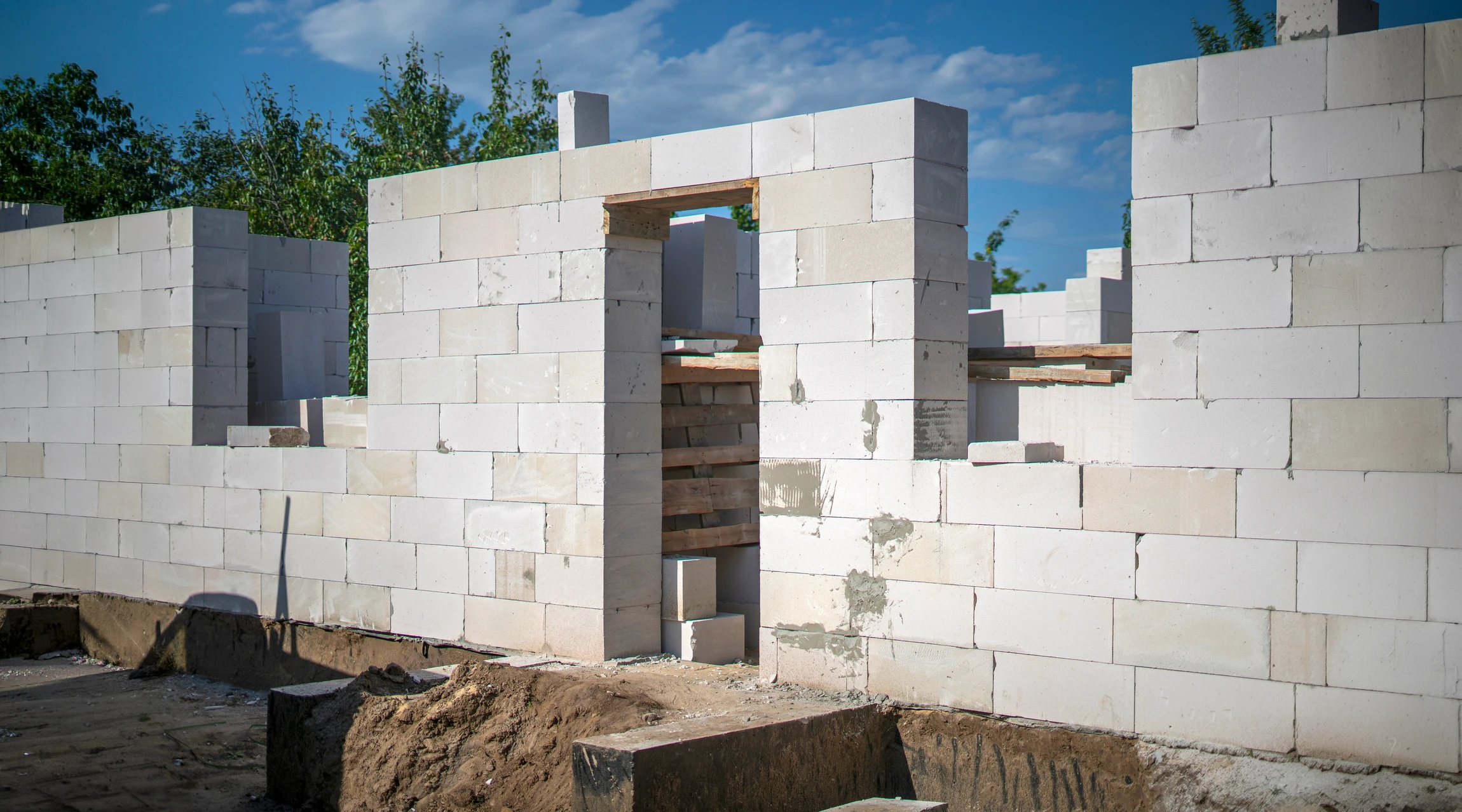 Chantier de construction urbain en extérieur avec ouvriers équipés de casques de sécurité travaillant sur une structure en béton armé
