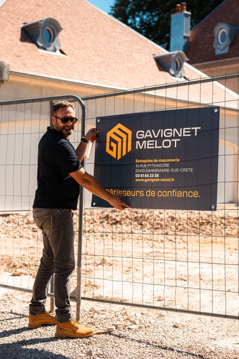 Chantier de construction extérieur avec deux professionnels du bâtiment consultant des plans architecturaux